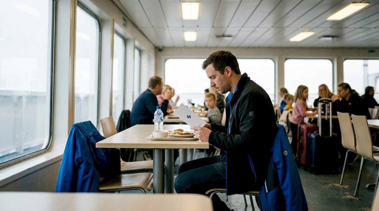 Un passager du ferry en train d’étudier la carte pour choisir son plat.