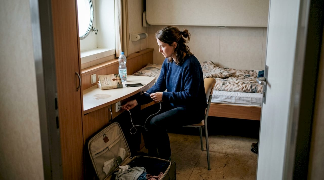 Eine Frau räumt ihren Schreibtisch in ihrer Kabine auf der Fähre ordentlich auf.