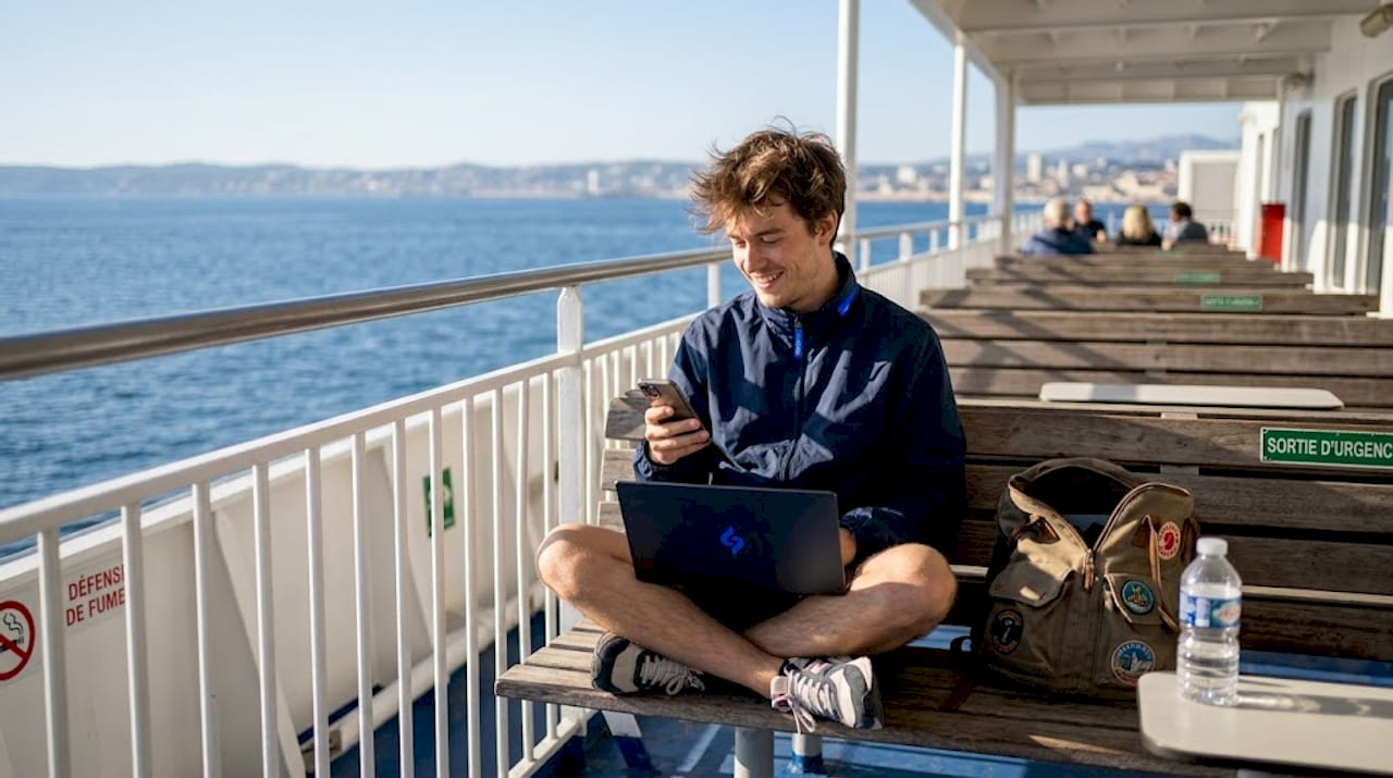 Un passager profite du wifi sur le pont du ferry pour regarder des vidéos en streaming.