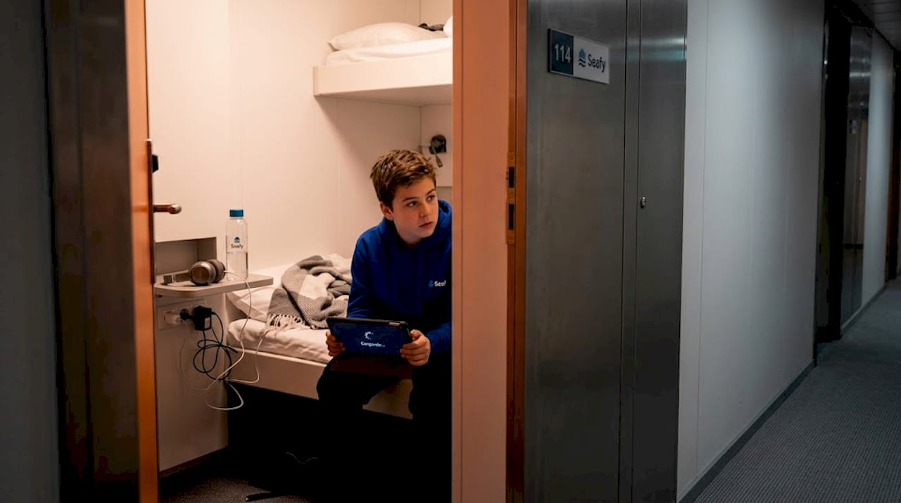 Un adolescente peleándose con el wifi en el camarote