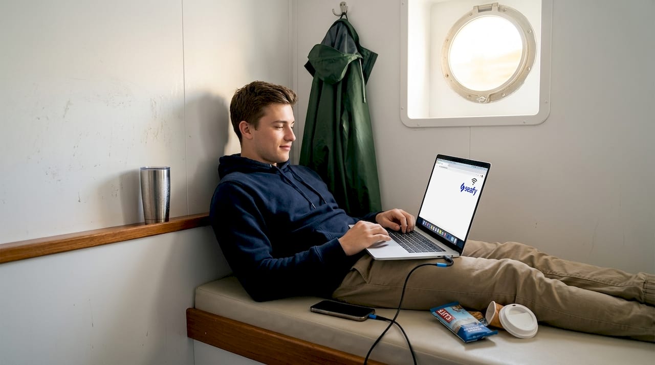 Traveler checking Wi-Fi signal on laptop in ferry cabin