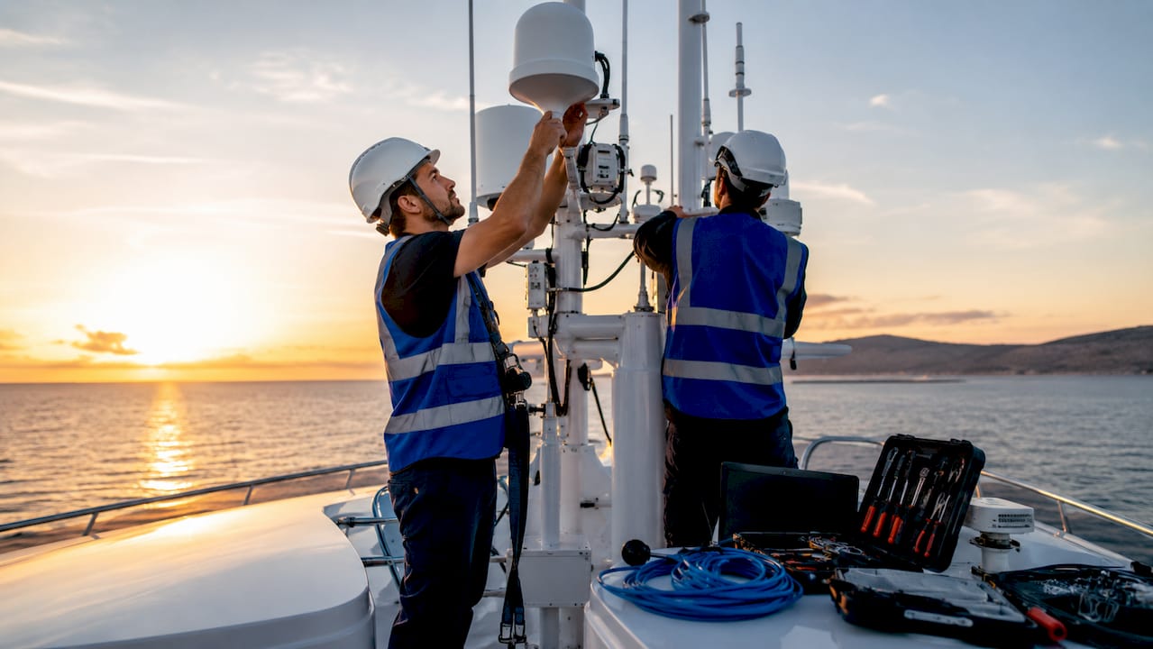 Especialistas trabajando en la instalación de sistemas de conectividad a bordo de un barco en pleno mar.