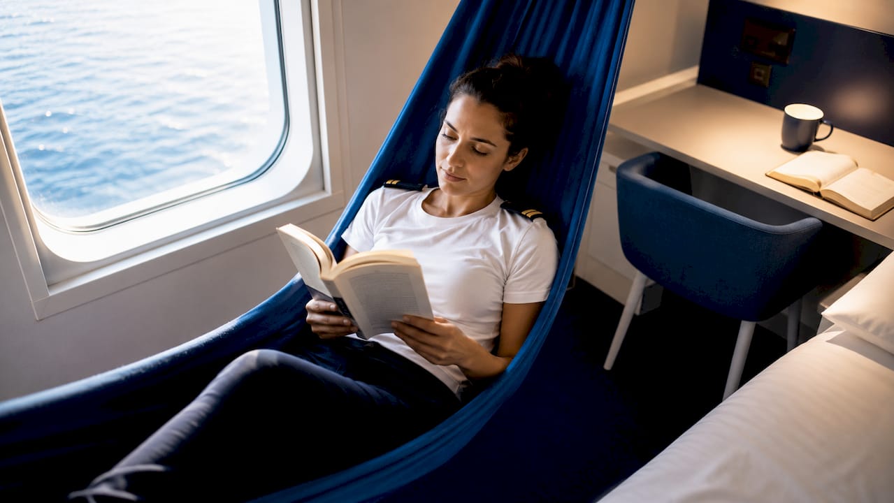 Tripulante disfrutando de un merecido descanso en su camarote privado a bordo