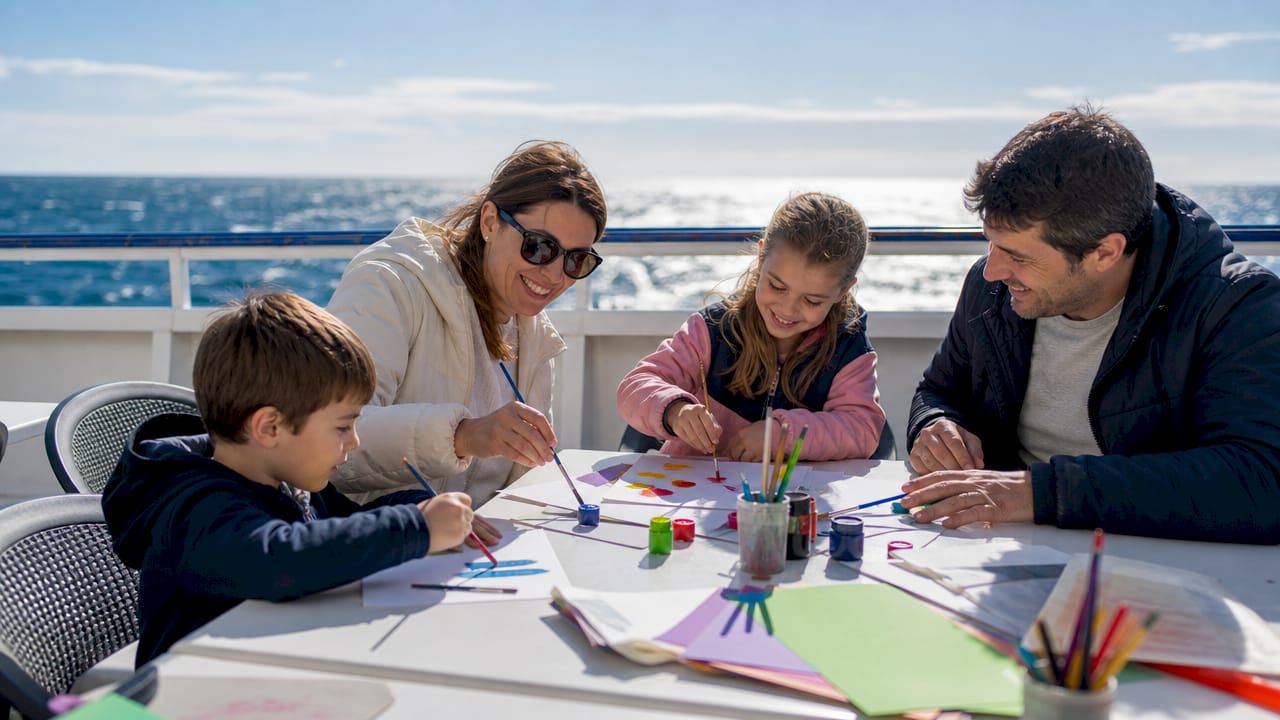 Una familia se divierte participando en un taller de manualidades durante el viaje.