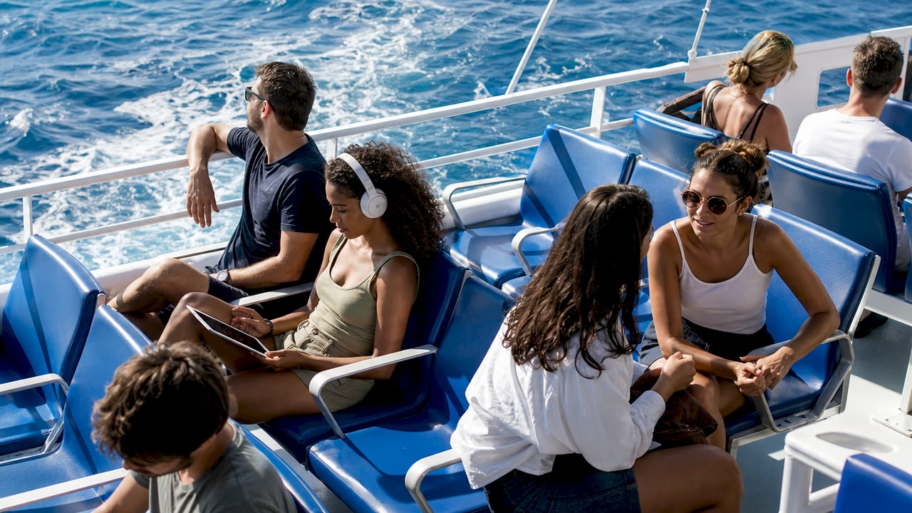 Los viajeros aprovechan la conexión a internet mientras navegan en el ferry.