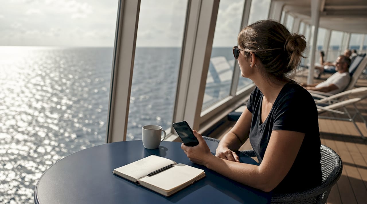 Eine Passagierin überprüft mit einer WLAN-Analyse-App die Netzqualität an Bord eines Kreuzfahrtschiffs.