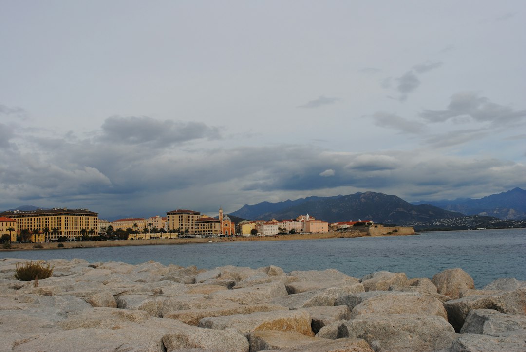 lungomare di Ajaccio con barche nel porto e montagne sullo sfondo