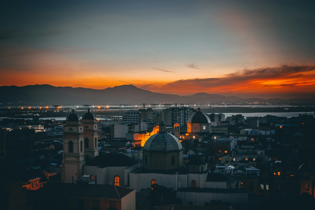 vue panoramique de Cagliari au coucher du soleil, avec Castello illuminé et la mer en arrière-plan
